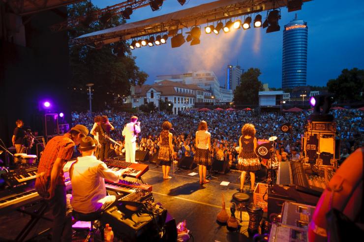 Blick von der Bühne, auf der eine Band steht, ins Publikum der Kulturarena Jena