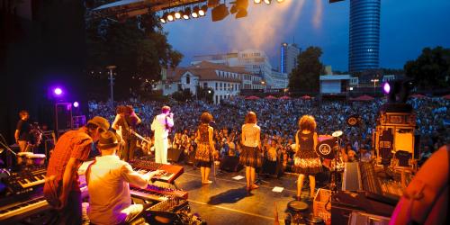 Blick von der Bühne, auf der eine Band steht, ins Publikum der Kulturarena Jena